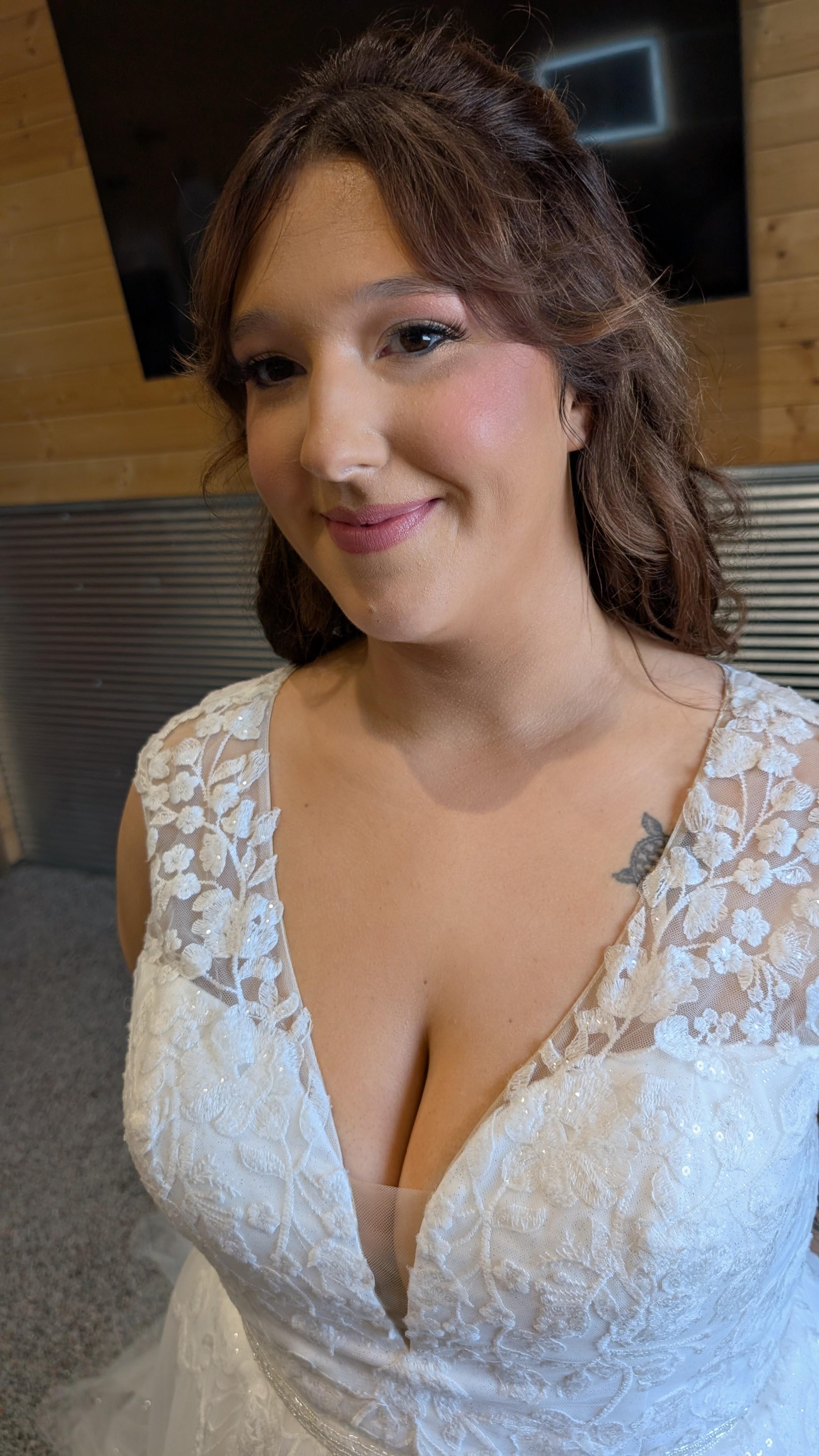 smiling bride in a lace v-neck gown with rosy soft glam and half-up waves